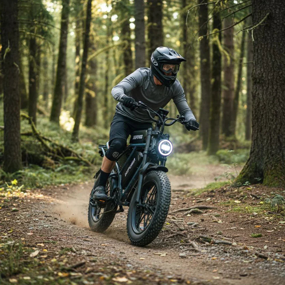 Man riding fat-tire electric bike on forest trail wearing helmet and protective gear